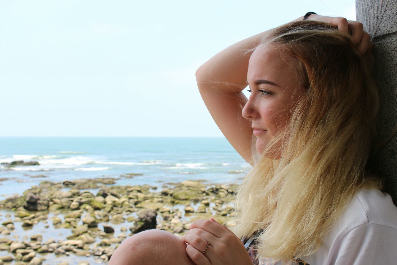 CLOSE-UP OF BEAUTIFUL WOMAN AGAINST SEA