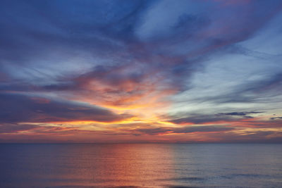 Scenic view of sea against dramatic sky during sunset