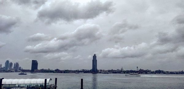 Scenic view of sea by buildings against sky