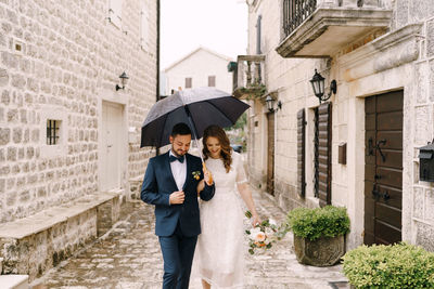 Rear view of woman holding umbrella