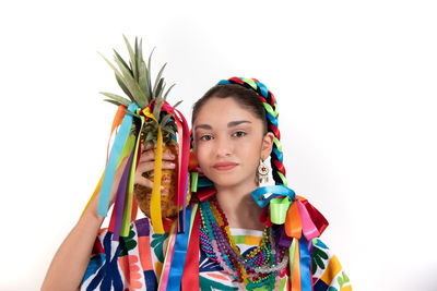 Portrait of woman holding colorful flowers against white background