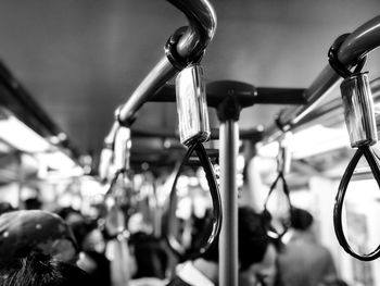 Close-up of handles hanging in train