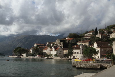 Buildings by sea against sky in town