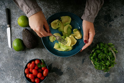 High angle view of woman holding fruits in bowl