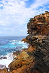 Rock formation on beach against sky