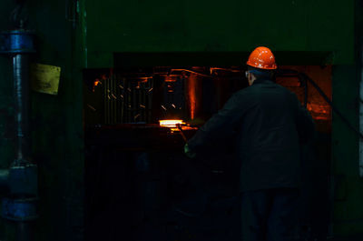 Rear view of man working in factory