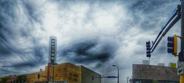 Low angle view of crane against cloudy sky