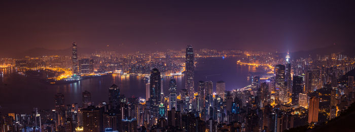 Illuminated cityscape against sky at night