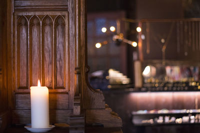 Close-up of lit candle in darkroom