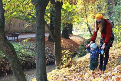 Mother and son in colorful forest during autumn