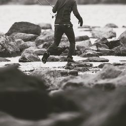 Low section of man standing at beach