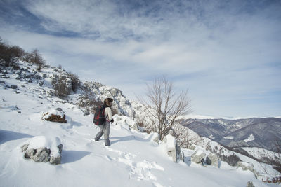 Person on snowcapped mountain against sky