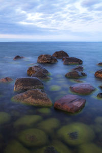 Rocks in sea against sky