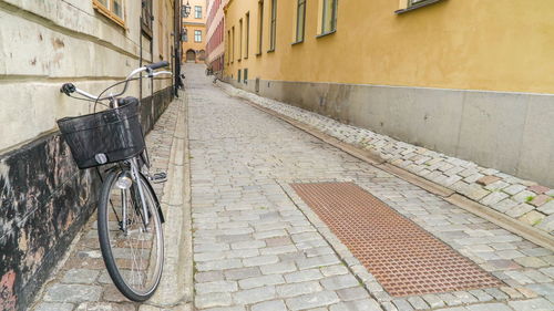 Bicycle parked on footpath amidst buildings in city