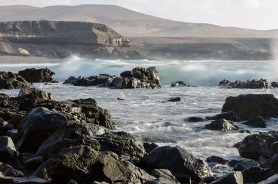 Scenic view of sea and mountains against sky