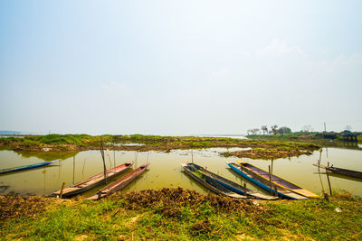 Boats moored in lake against sky