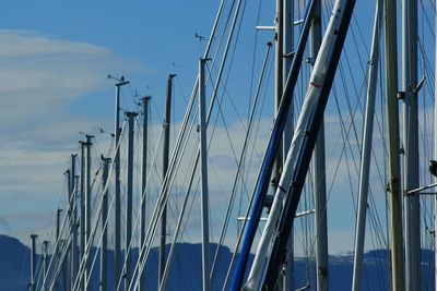 Low angle view of sailboats moored in sea against sky