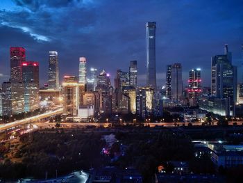 Illuminated buildings in city against sky at night