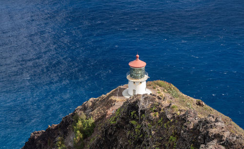 High angle view of lighthouse by sea against building