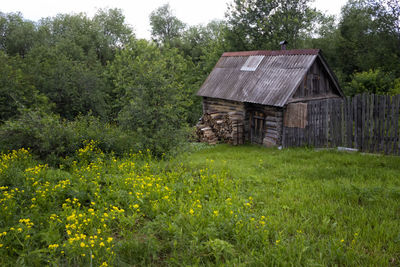 House on field against trees and houses