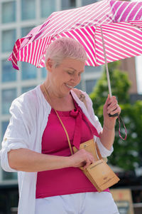 Middle-aged woman with a short haircut with an umbrella protecting from sun