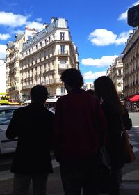 Buildings in city against cloudy sky