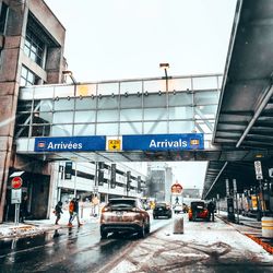 Cars on road against sky in city