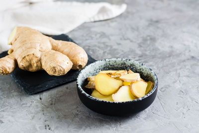 Sliced fresh raw ginger root in a bowl on the table. alternative medicine