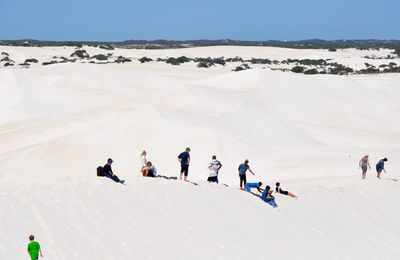 Side view of people on snow covered landscape