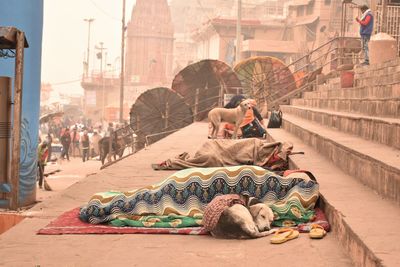 People relaxing on sidewalk in city