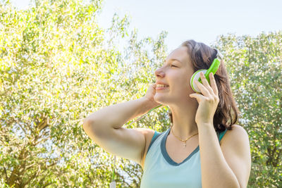 Portrait of a smiling young woman against plants