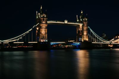 Suspension bridge over river at night