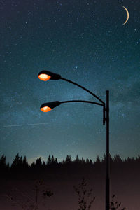 Low angle view of illuminated street light against sky at night