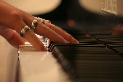 Cropped image of hand playing piano