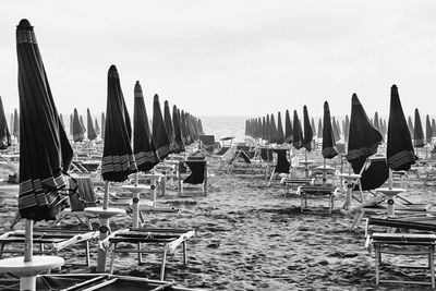 Panoramic view of lounge chairs on beach against sky