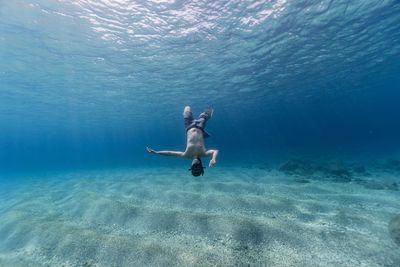 Full length of shirtless man swimming in sea