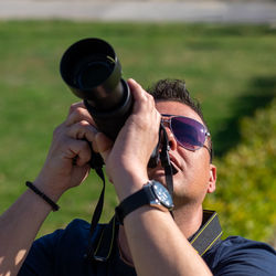 Close-up of man photographing with camera at park