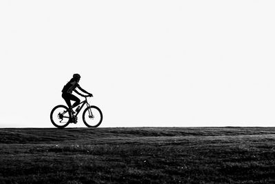 Man riding bicycle on field