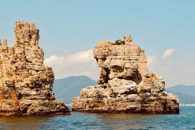 Rock formations in sea against sky