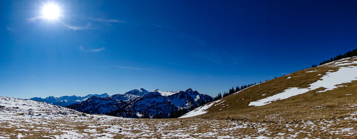 Scenic view of snowcapped mountains against blue sky