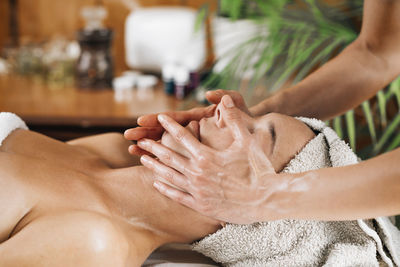 Woman enjoying a professional ayurvedic facial massage with therapeutic oils