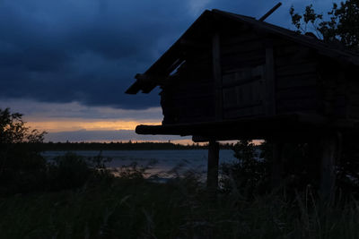 Scenic view of lake by silhouette building against sky