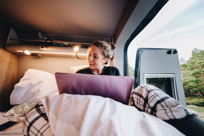 Young woman using laptop in camper