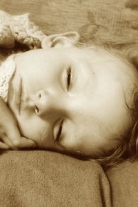 Close-up of baby sleeping on bed at home