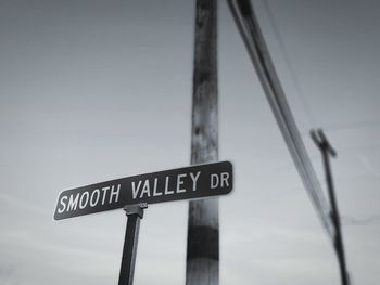 Low angle view of road sign against clear sky