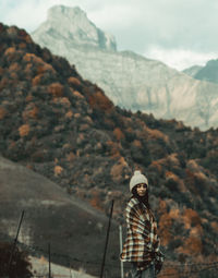 Portrait of woman standing against mountains