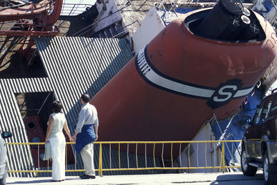 People standing on railing of boat