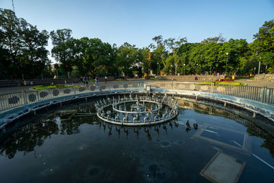 High angle view of people in park by lake against sky