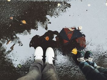 Low section of person standing in puddle