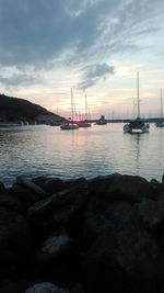 Boats in sea at sunset